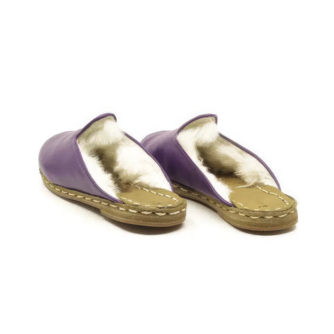 Pair of purple and gold sandals on a white background